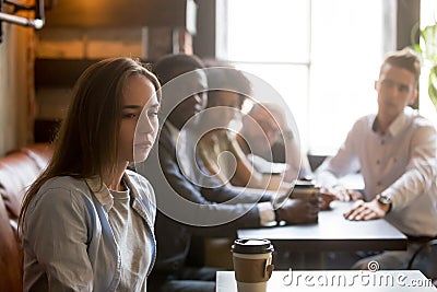 Offended girl ignoring friends apologizing after bad joke Stock Photo