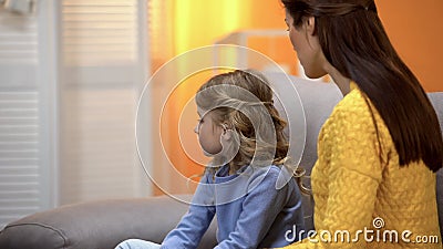 Offended girl turned away from mother, mom scolding daughter for bad behaviour Stock Photo