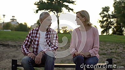 Offended senior couple sitting on bench and looking at each other, relationships Stock Photo