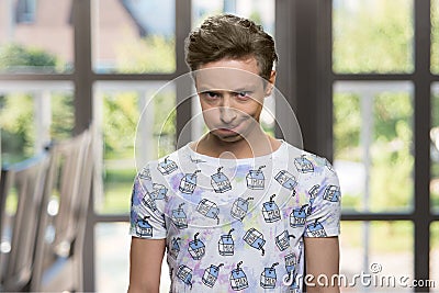 Offended teen boy on windows background. Stock Photo