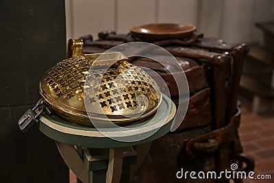 Offertory box made of brass with an iron lock in a Christian church, used to collect money for charitable or religious purposes Stock Photo