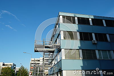 Office building with external metal staircase in the middle of a residential area Stock Photo