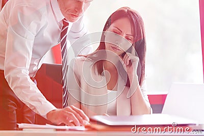 Businesswoman concentrating while colleague explaining at desk Stock Photo