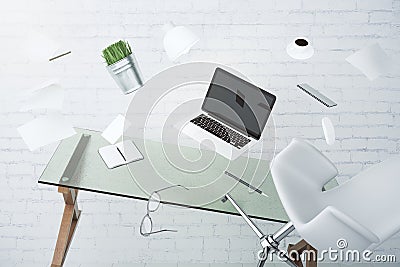 Office chaos concept with laptop, furniture and other accessories flying in the air Stock Photo