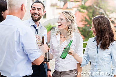 Office colleagues drinking beer after work Stock Photo