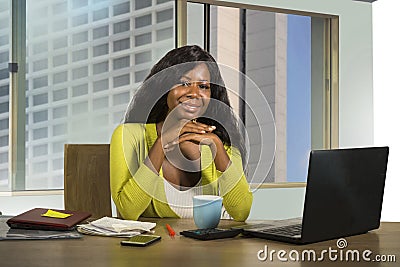 Portrait of young happy and beautiful black African American businesswoman working confident at computer desk smiling satisfied in Stock Photo