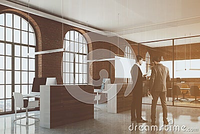 Office cubicles in brick office corner, people Stock Photo