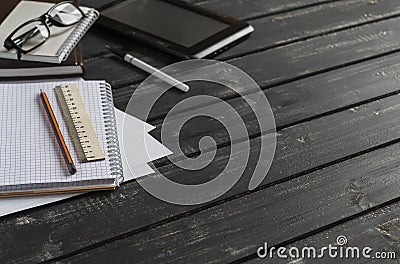 Office desk with business objects - open notebook, tablet computer, glasses, ruler, pencil, pen. Free space for text. Stock Photo