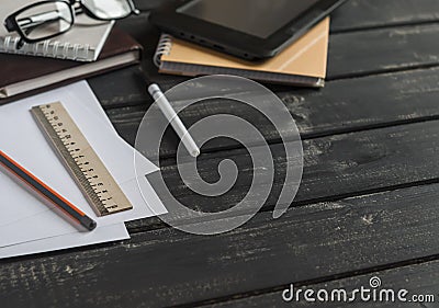 Office desk with business objects - open notebook, tablet computer, glasses, ruler, pencil, pen. Free space for text. Stock Photo