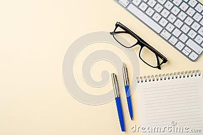 Office desk with computer keyboard, glasses, notebook and pen. Top view with copy space. Flat lay Stock Photo