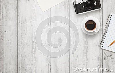 Office desk with free space for text. Camera, cup of coffee, paper, notepad, pencil on white wooden table Stock Photo