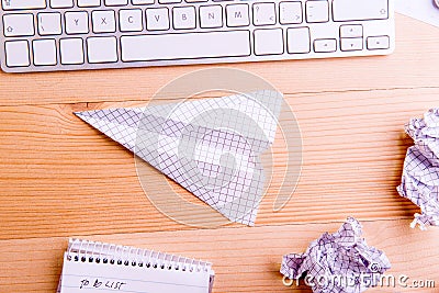 Office desk, paper airplane. Studio shot, wooden background. Stock Photo