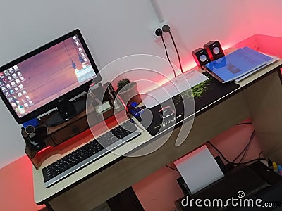 Office desk setup, student desk, lights, computer, keyboard, speaker, mouse, flower, LED Editorial Stock Photo