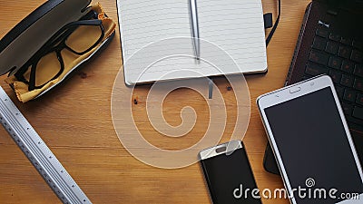 Office desk table with glasses, laptop, phone, tablet, notebook and ruler Stock Photo