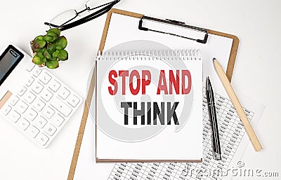 Office desk table with paper sheet, notepad ,chart and calculator. Top view, text STOP AND THINK Stock Photo