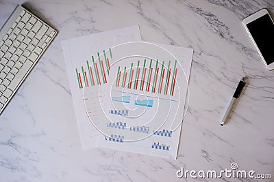 Office desk table with Smartphone, keyboard and pen with fundamental graph diagram in white paper Stock Photo