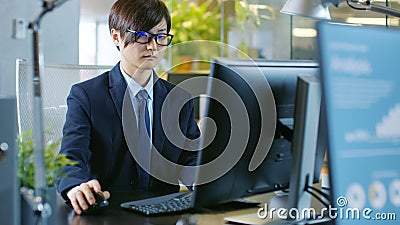 In the Office East Asian Businessman works on a Desktop Personal Stock Photo