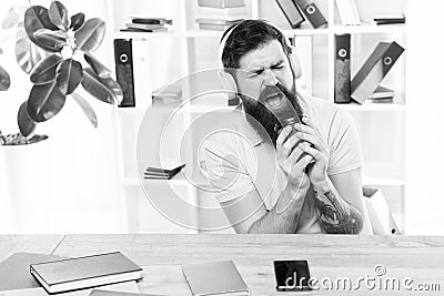 Office life rhythm. Regular office day. Man bearded guy headphones sit office listen music sing song. Worker with coffee Stock Photo