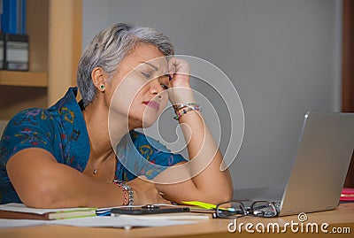 Office lifestyle portrait of sad and depressed mature attractive Asian woman working on laptop computer desk stressed and tired Stock Photo