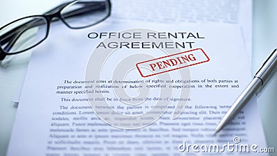 Office rental agreement pending, hand stamping seal on business document, close Stock Photo