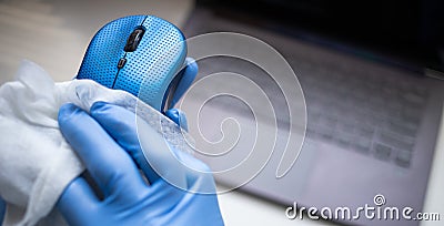 office sanitizing wipe wiping mouse and mousepad with disinfecting wipes. Coronavirus COVID-19 sanitize cleaning disinfection of Stock Photo