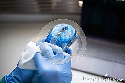 office sanitizing wipe wiping mouse and mousepad with disinfecting wipes. Coronavirus COVID-19 sanitize cleaning disinfection of Stock Photo