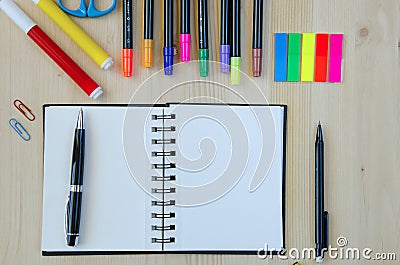 Office supplies laying on a wooden desk background.Top view. Pencils,scissors,markers,stickers,bookmarks,glasses Stock Photo