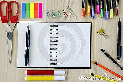 Office supplies laying on a wooden desk background.Top view. Pencils,scissors,markers,stickers,bookmarks,glasses Stock Photo