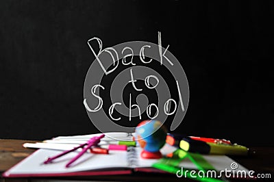 Office supplies spread out on a notebook lying on a table on the background of a chalk lettering time to school Stock Photo