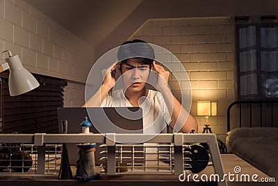 office syndrome concept Asian freelancer feeling stressed and having headache during nightshift Stock Photo