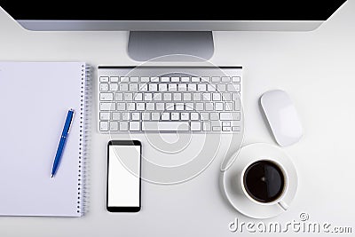 Office table with computer, wireless computer keyboard and mouse, cup of coffee, tablet smartphone.copy space notebook. empty scre Stock Photo