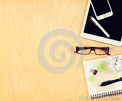 Office table with digital tablet, smartphone, reading glasses and notepad. View from above Stock Photo