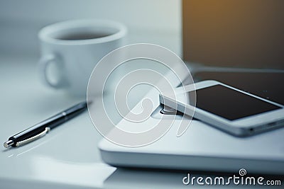 White office table with laptop, coffee, smartphone and pen. Stock Photo