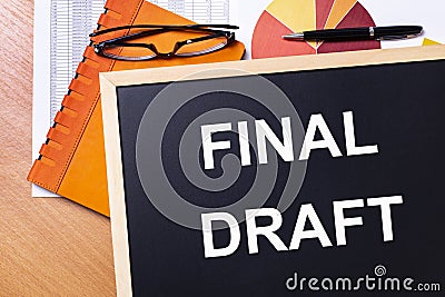 On the office table is an orange notepad, black glasses, a pen and a note-board with the text FINAL DRAFT Stock Photo