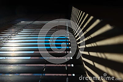 Office or window blinds or jalousies with shadows on the wall. Stock Photo