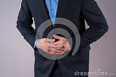Office worker with abdominal pain, stomach ache on gray background Stock Photo