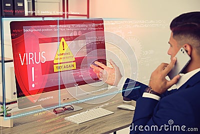 Office worker in front of computer with warning about virus attack on screen Stock Photo