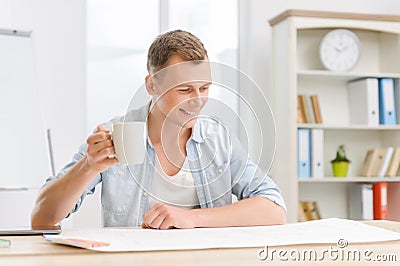 Office worker observes the drawing while drinking Stock Photo