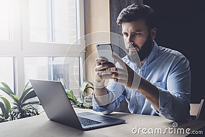 Office worker relaxing, playing online games on smartphone. Man downloading apps on his mobile device. Male checking email Stock Photo