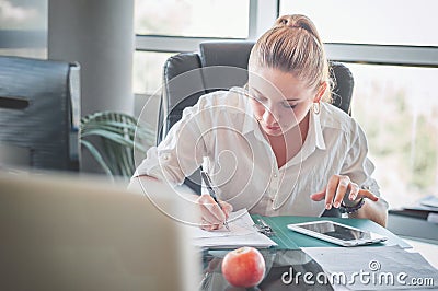 Office worker at workplace. Girl writing on paper. Stock Photo