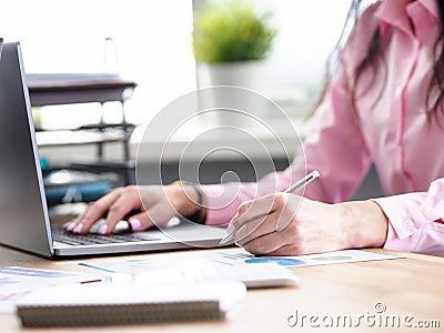 Office worker writes notes and prints on laptop Stock Photo