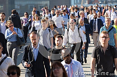 Office workers crossing the London bridge in early morning on the way to the City of London, UK Editorial Stock Photo