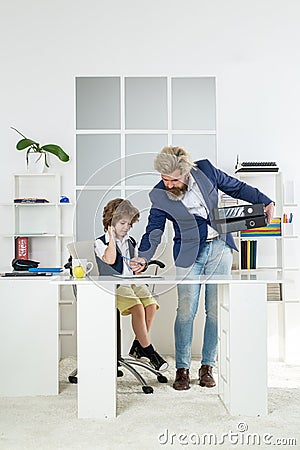 Office workers. Family business. Little boy dreaming about businessman profession. Father and son at meeting in modern Stock Photo