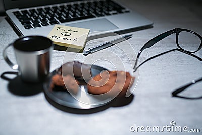 Office working desk with laptop, pen and and glasses and coffee with cookie and stickers or memo notes Stock Photo