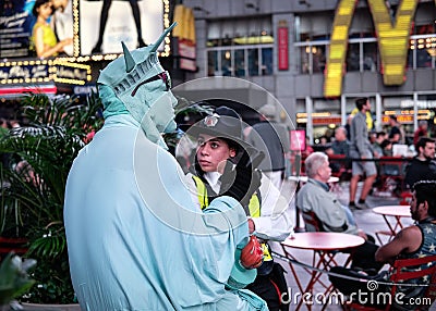 NYPD Police officer seen talking to a street entertainer in Times Square, New York City, USA. Editorial Stock Photo