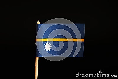 A official flag of nauru on wooden stick on black background. A nauru is island state and belongs to oceania Stock Photo