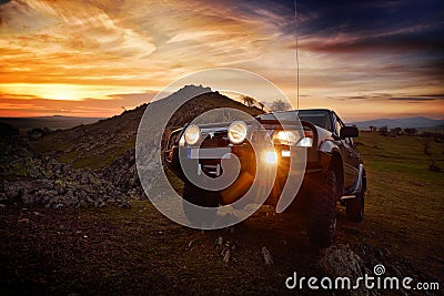 Offroad car on mountain road at sunset Stock Photo