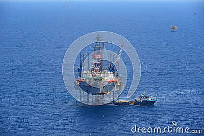 The offshore drilling oil rig and supply boat side view Stock Photo