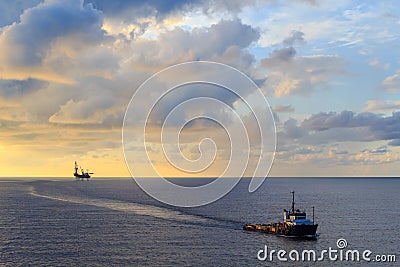 Offshore jack up drilling rig and supply boat Stock Photo