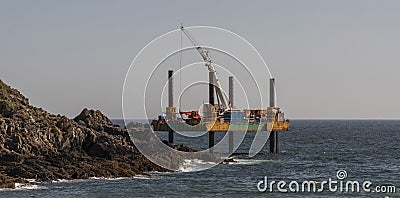 Offshore Jack Up work platform. Covering a submerge outfall pipe with concrete. Cornwall, UK Editorial Stock Photo